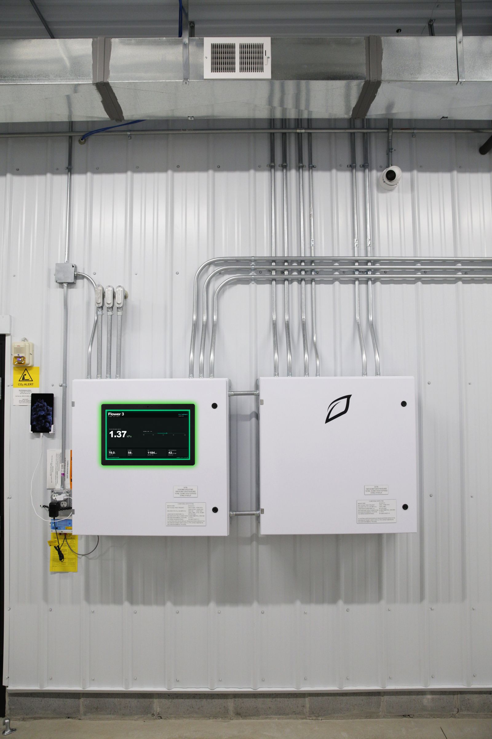Growlink Core controller with displayLINK room dashboard in facility hallway showing real-time VPD and climate data